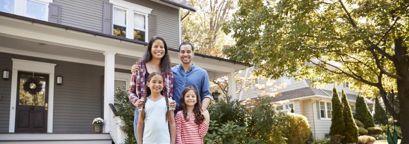 family standing in front of a house